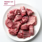 Fresh bone-in mutton curry cut pieces on a white plate